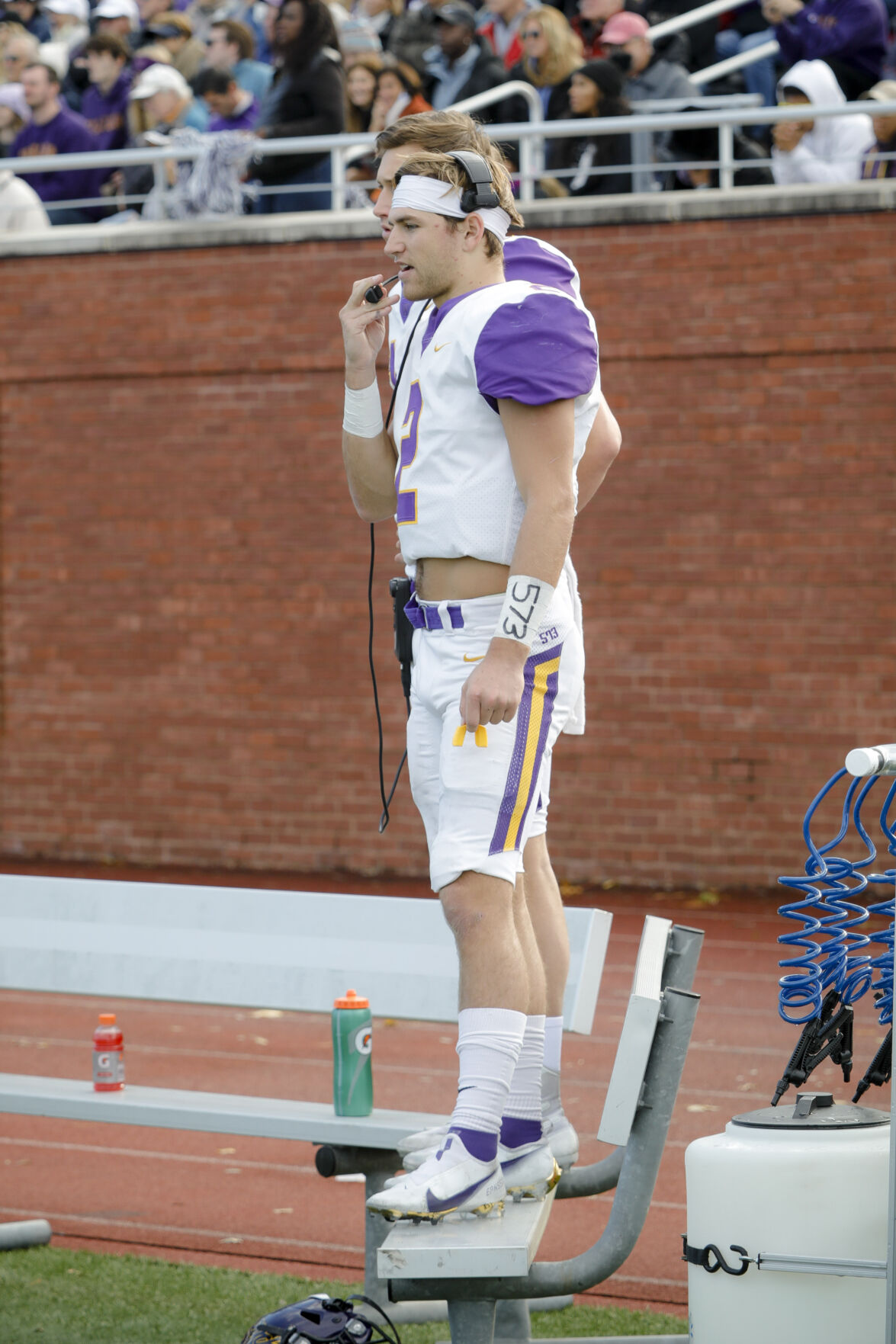 bobby maimaron stands on bench talking into headset